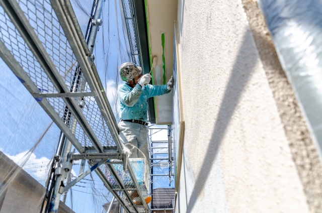 湖南市の住宅で足場を組んで屋根と外壁を塗装している様子