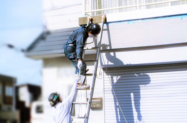 はしごをかけた住宅の屋根