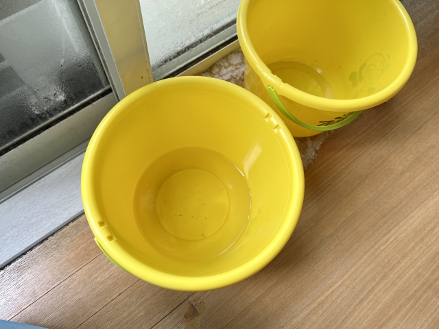 雨漏りの下にバケツとタオルを置いている様子